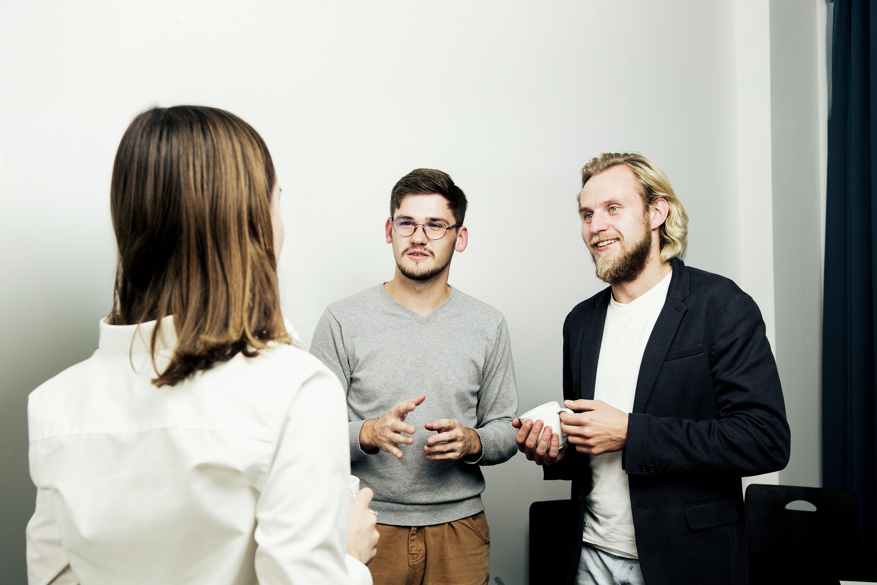 Three people discussing over a cup of coffee. 