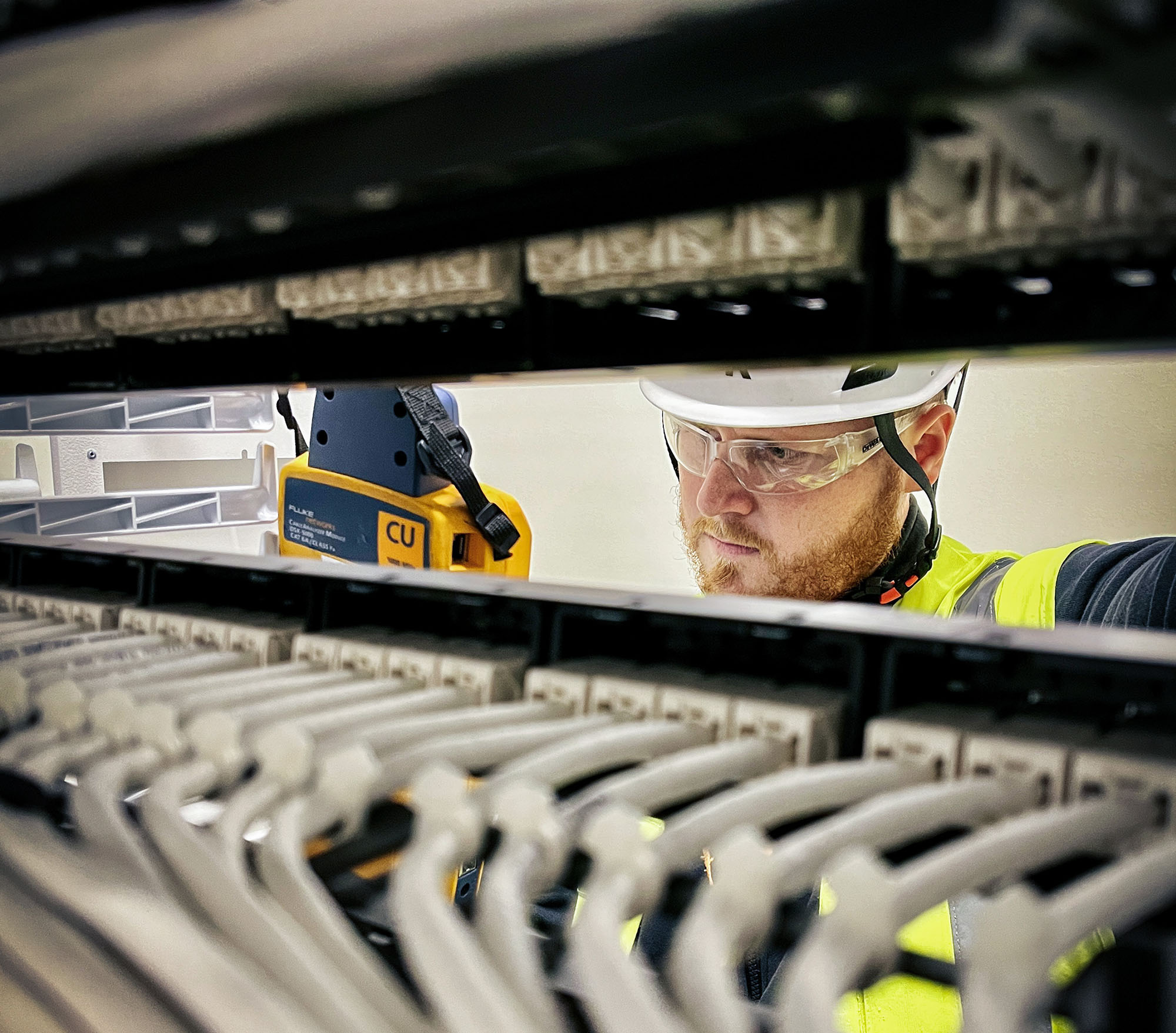 One person working with installation seen between data center racks.