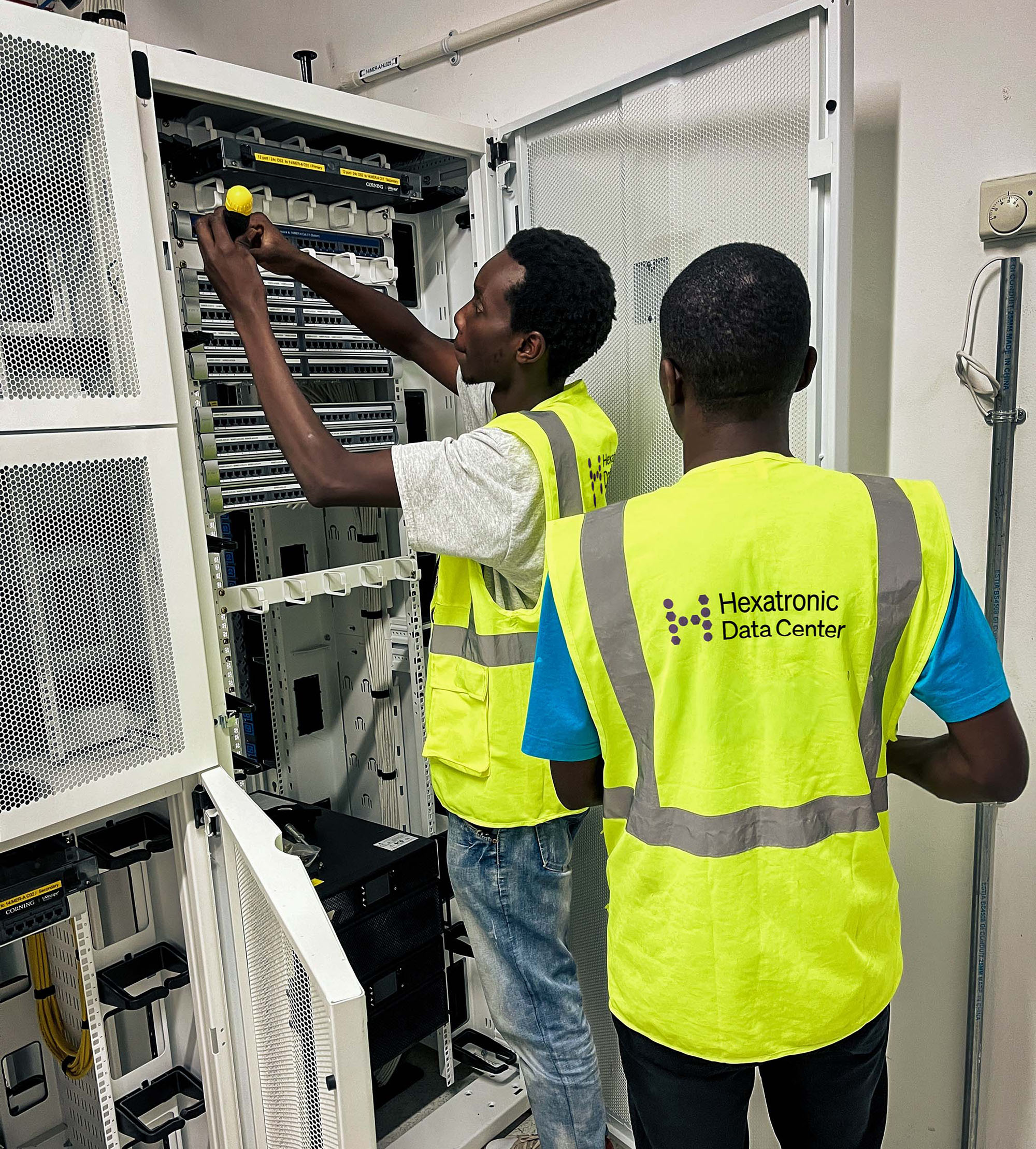 Two persons working with installation in a data center cabinet..