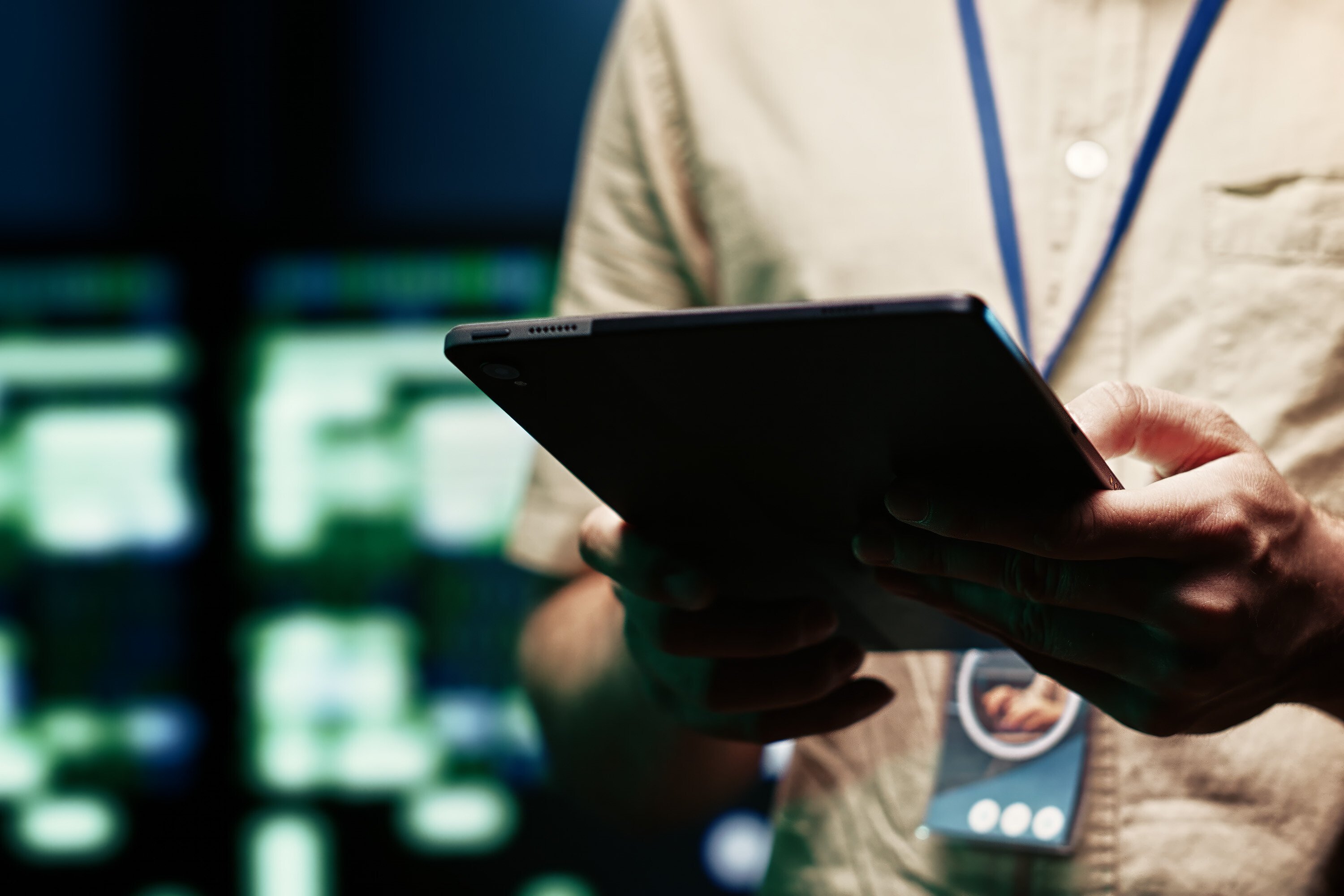 Person working on an ipad in a data center. The background is blurry. 