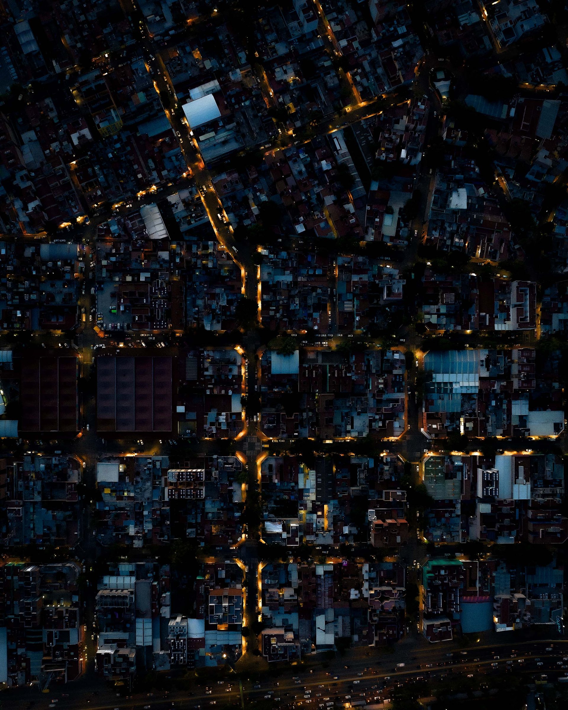 A lit-up suburb captured from straight above at night.
